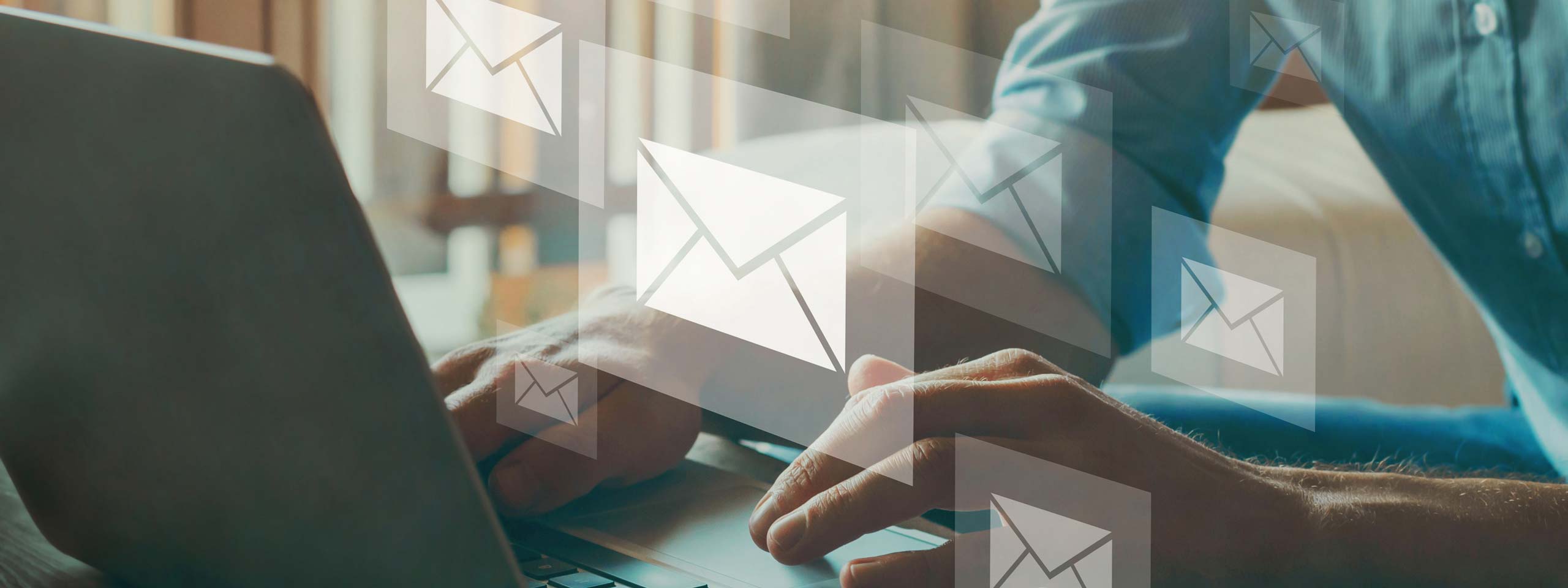 A person using a laptop with email icons in the background, focusing on their work.