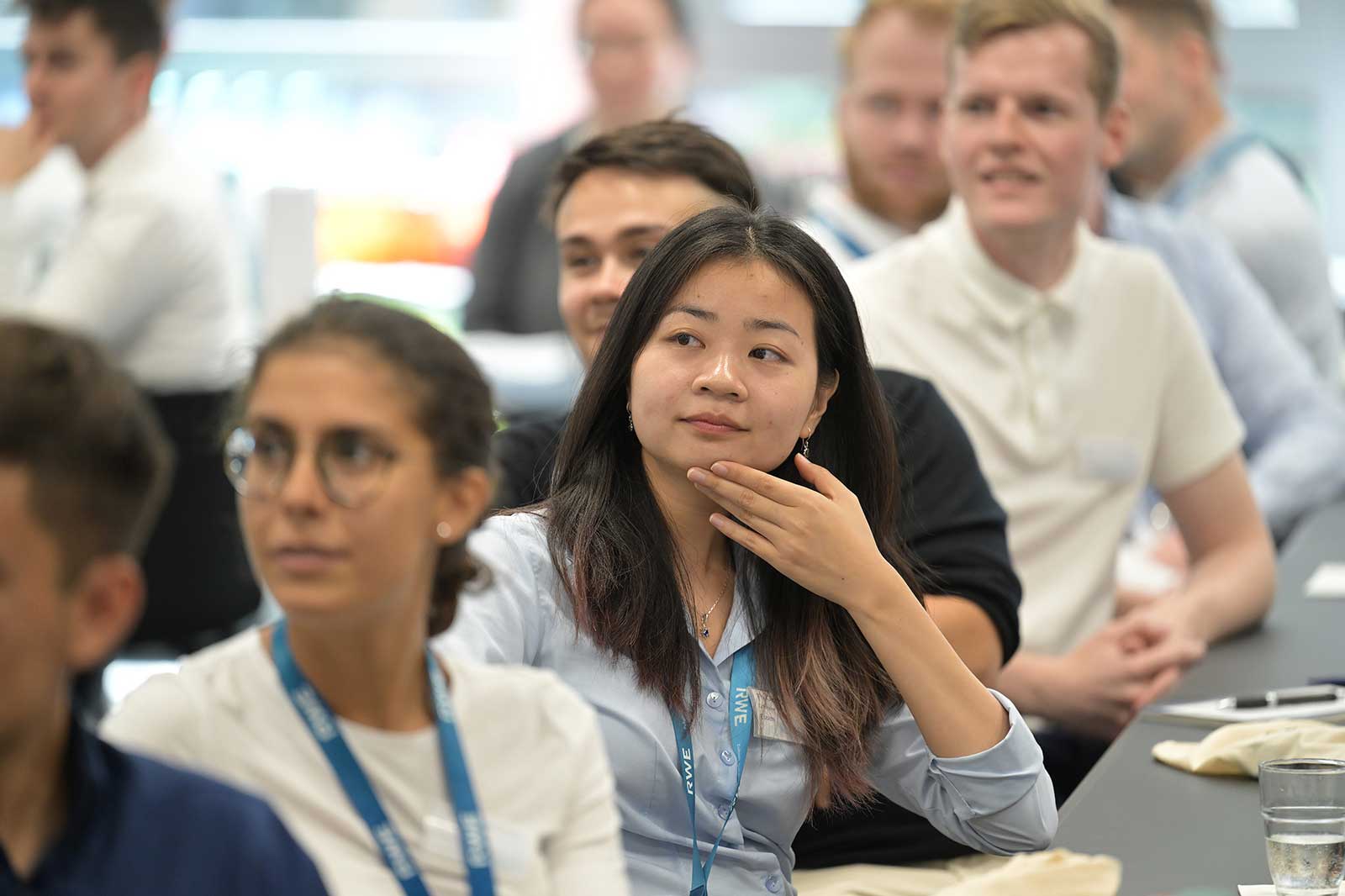 A group of individuals in a conference room, focused on a presentation.